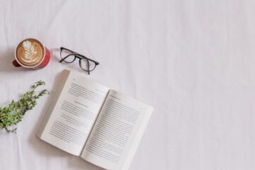 book page beside eyeglasses and coffee
