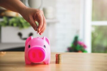 Free photo hand putting coints into piggy bank saving money and money planning financial concept