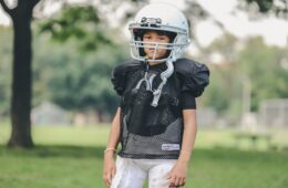 selective focus photography of boy wearing American football gear